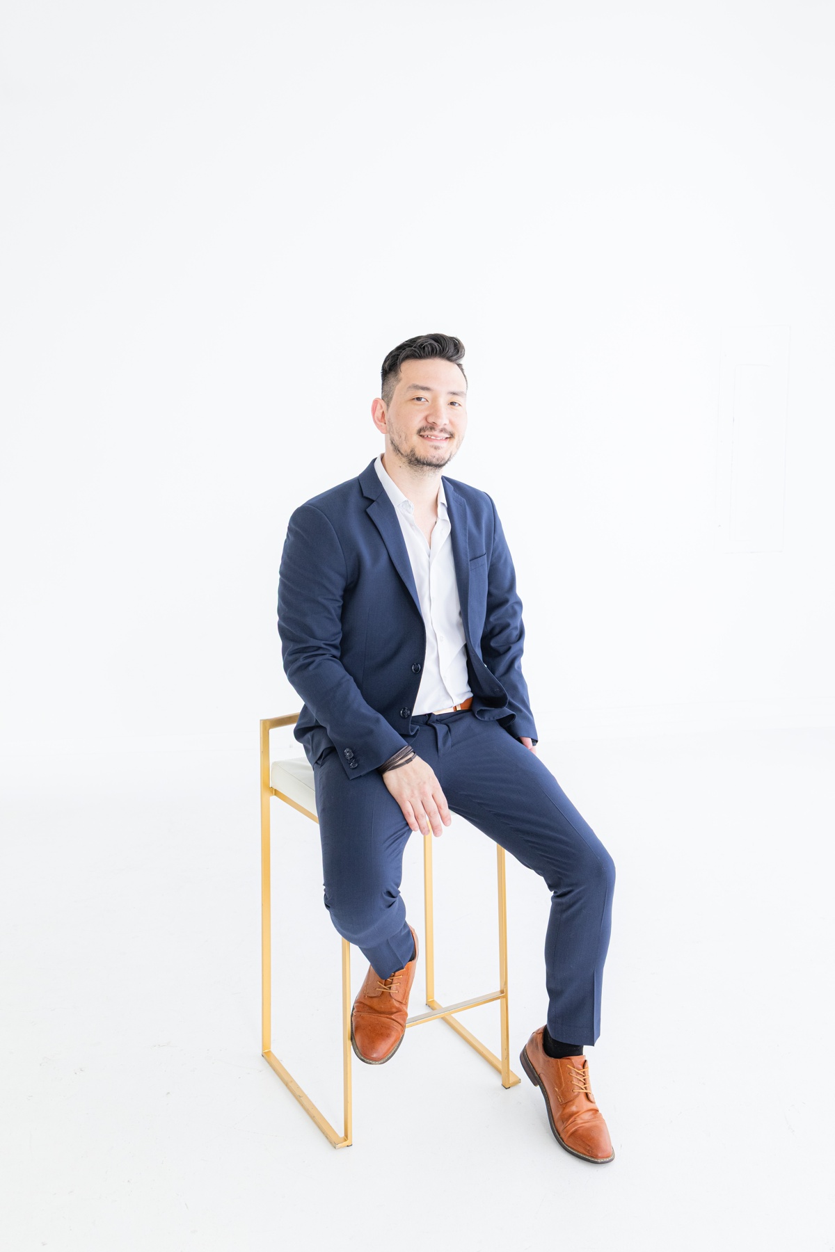 Josh Lewis seated in a bright studio portrait